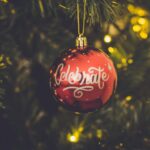 red celebrate print baubles hang on green christmas tree
