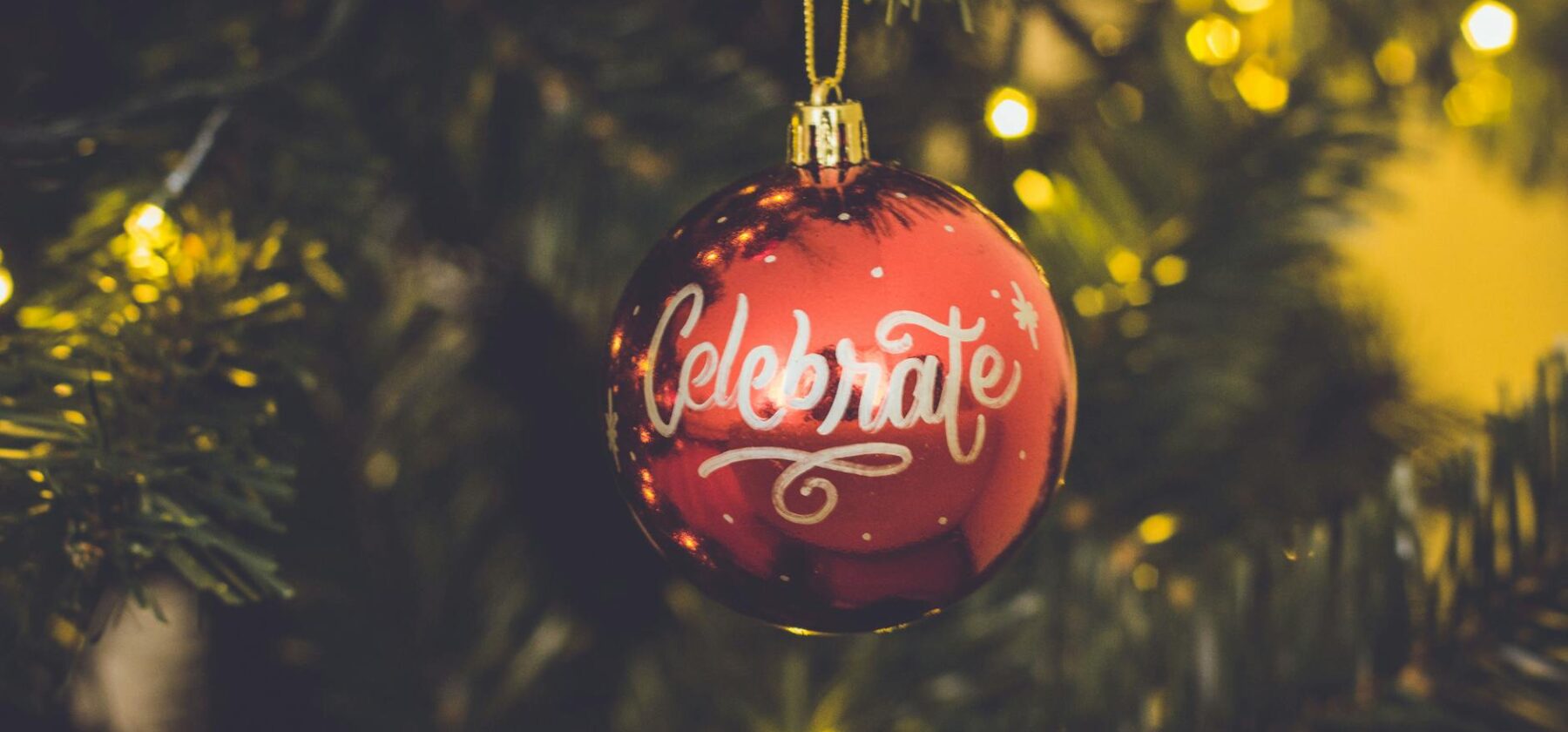 red celebrate print baubles hang on green christmas tree