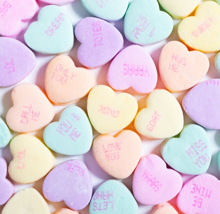 a large pile of candy hearts with the words love you